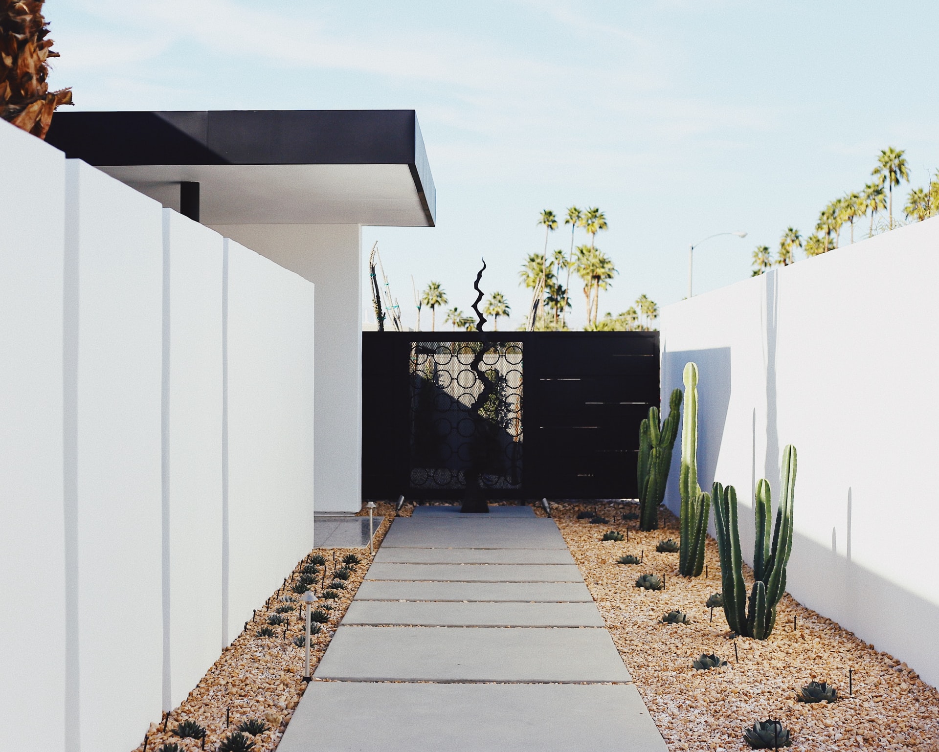 maison blanche avec marche jusqu'au portail avec cactus