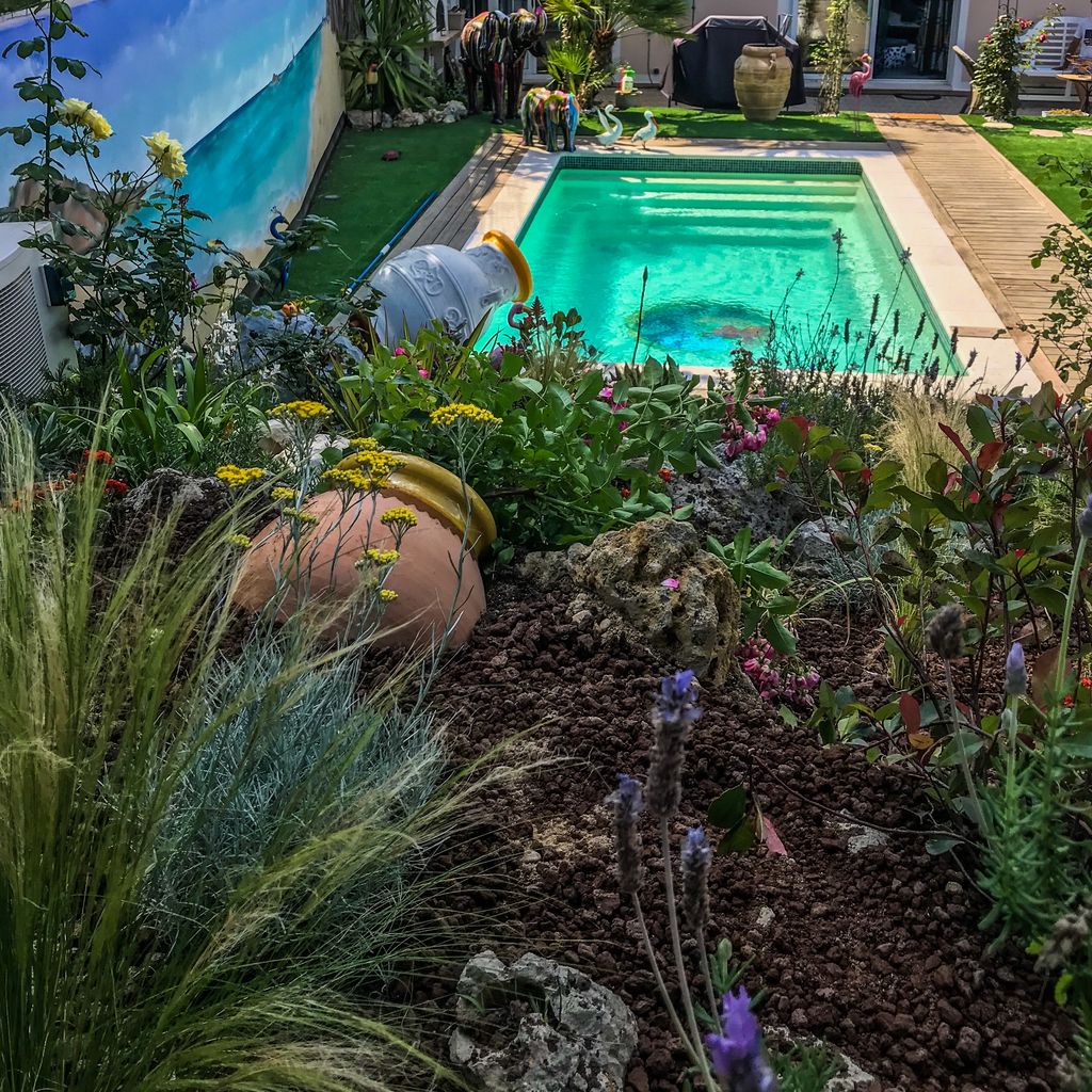 jardin avec piscine en fond et une jarre